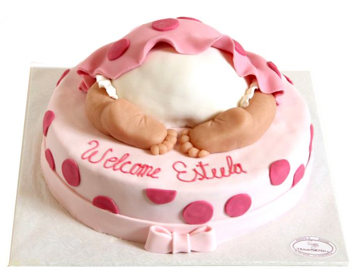 Rosa Babyshower-Tauftorte mit kleinen Babyfüßchen, weicher Decke und Welcome-Baby-Schriftzug