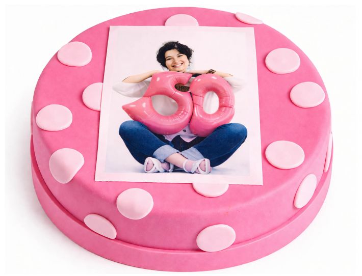 Frontal aufgenommene pinke Fototorte mit weißen Punkten und Fotoaufleger