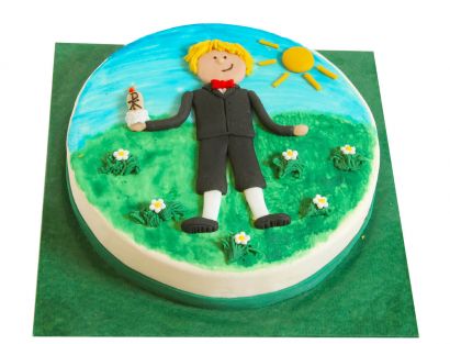 Kommunionstorte mit Jungenfigur auf Wiese